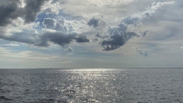 Cool reflections on Charlotte Harbor with the sun shining thru blue and cloudy skies.